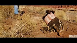 Huge-booty blonde gets her anus whipped, then gets rough anal sex in dirt and piss -- a real BDSM session outdoors in the Western USA with Rebel Rhyder