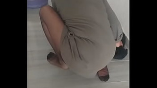 Older woman in turbanli nylon stockings wipes floors