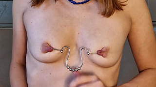Tortura and stretching of pierced nipples with paper clips